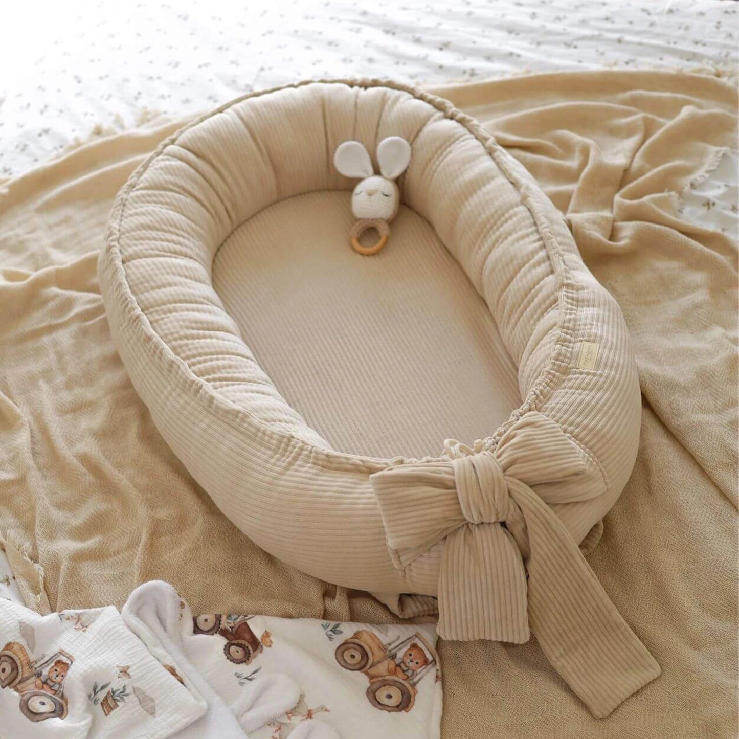 Baby Nestchen aus Cord in Beige in der gesamten Ansicht auf Bett