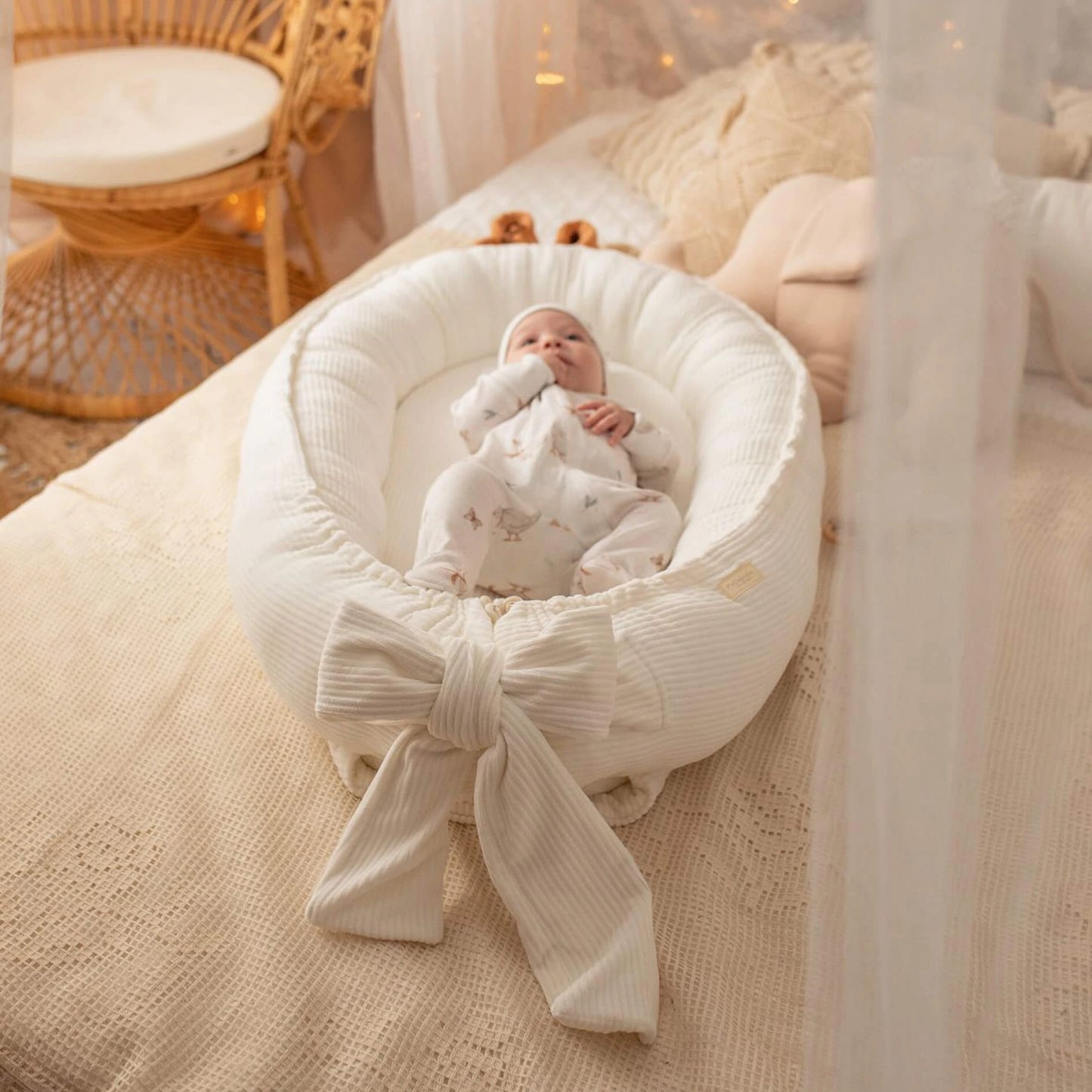 Baby Nestchen aus Cord in Creme mit Baby auf Bett