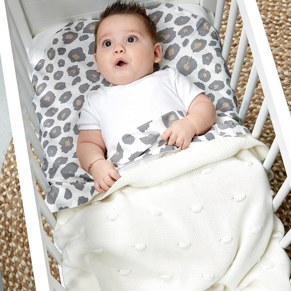 Meyco Babydecke in offwhite mit Baby im Bett