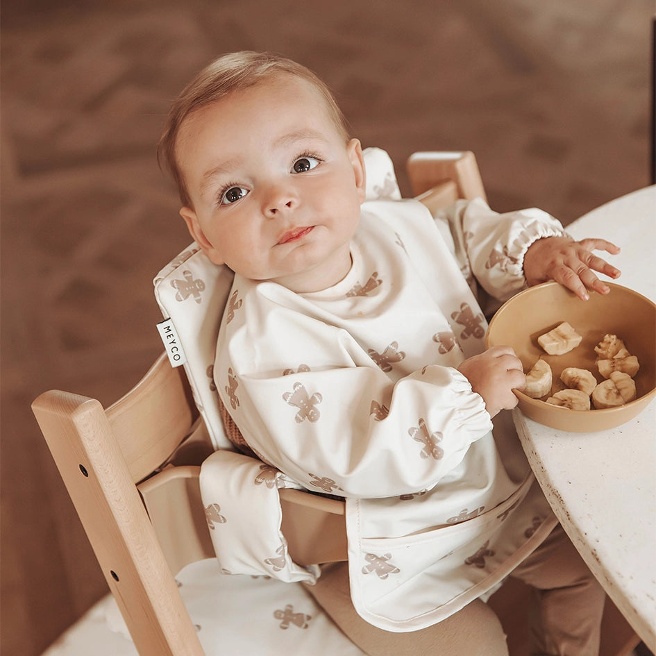 aermellaetzchen im lebkuchendesign der marke meyco mit baby in hochstuhl 