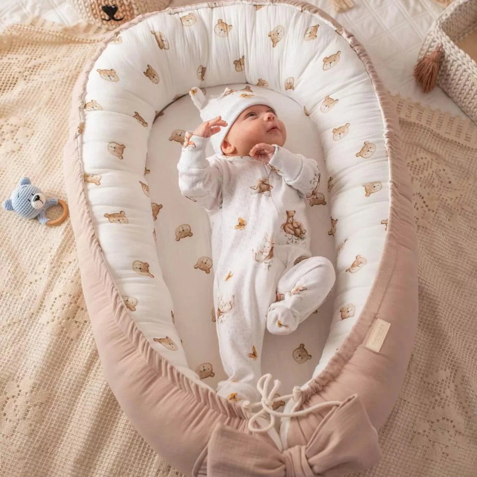 Baby Nestchen Rosa im Teddydesign mit darin liegendem Baby 