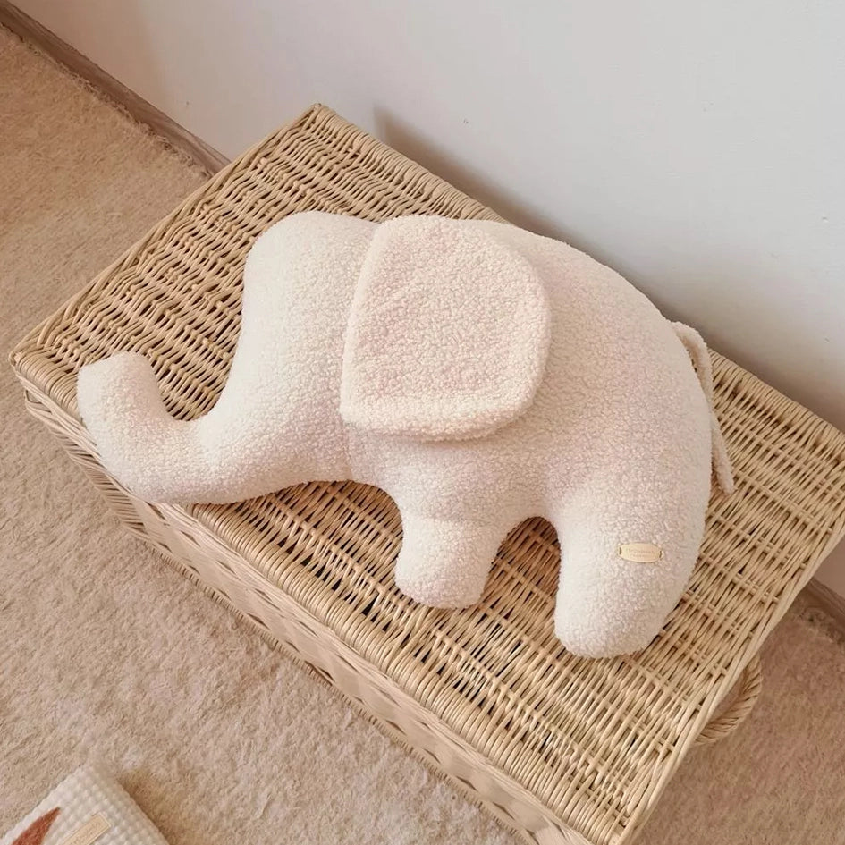 kuscheliges elefantenkissen in creme in gesamtansicht auf korb liegend
