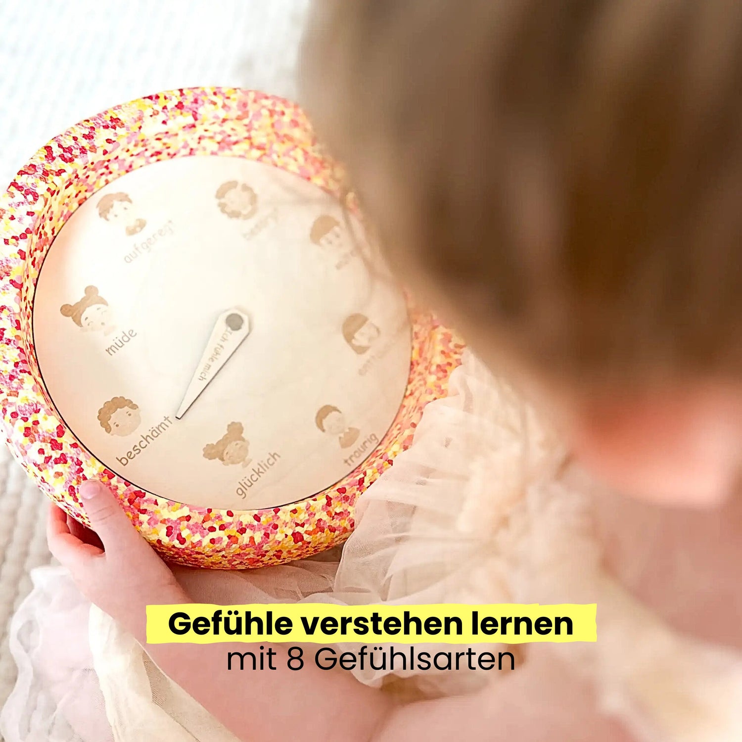 Kind nutzt Montessori Gefühlsrad auf stapelstein - spielerisch Emotionen verstehen lernen